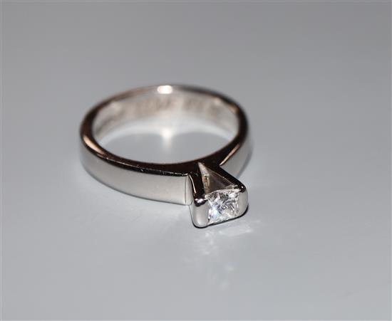 A modern 750 white metal and princess cut solitaire diamond ring, (stone chipped), size L/M, gross 6.7 grams.